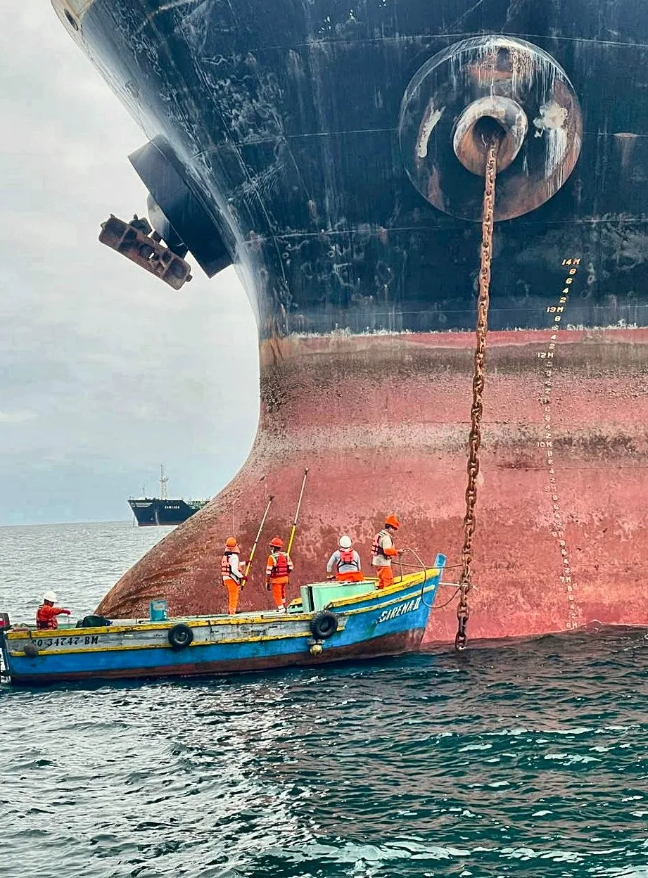 Equipo de ULISUB maniobrando cadena de ancla junto al casco durante un reflote